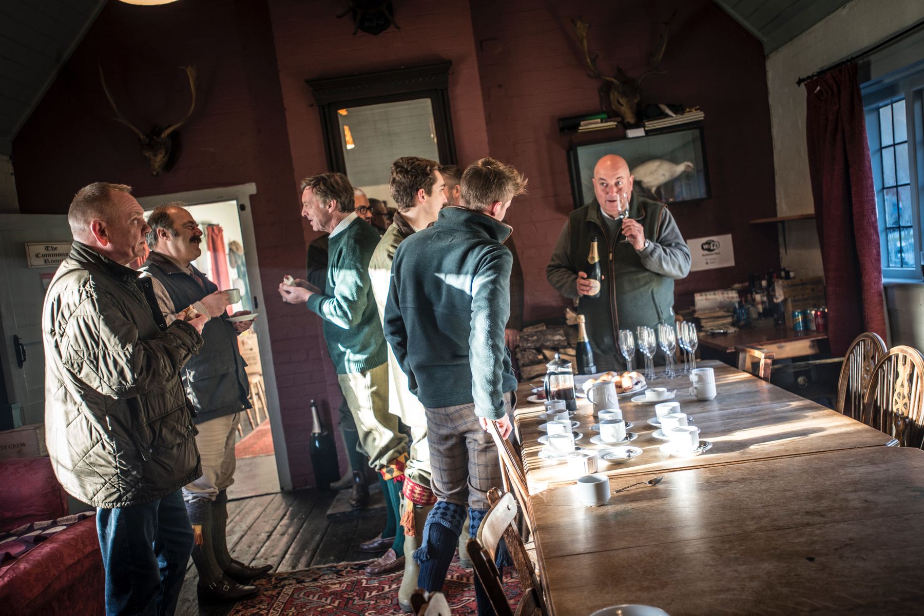 Guns gathered in the gun room with coffee and champagne after a driven clay day