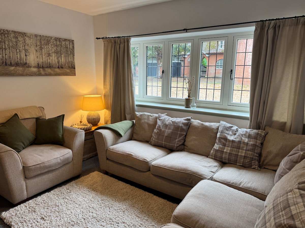 A sitting room with a linen sofa looking onto the courtyard